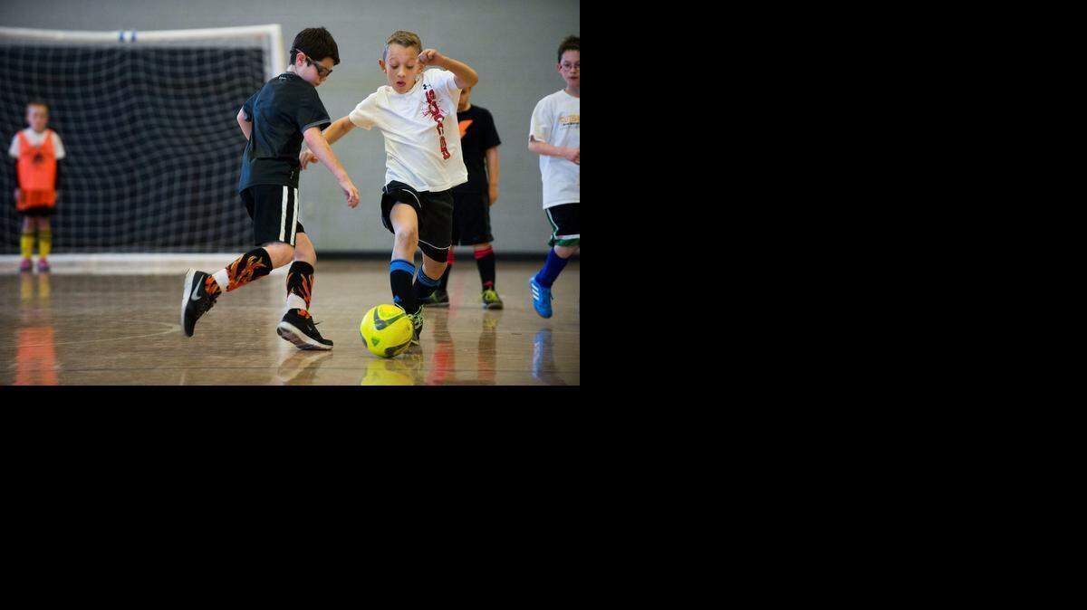 
James Hendrix, 9, left, defends as Payton Coss, 9, advances the ball in a futsal game in Rocklin on Saturday. 
