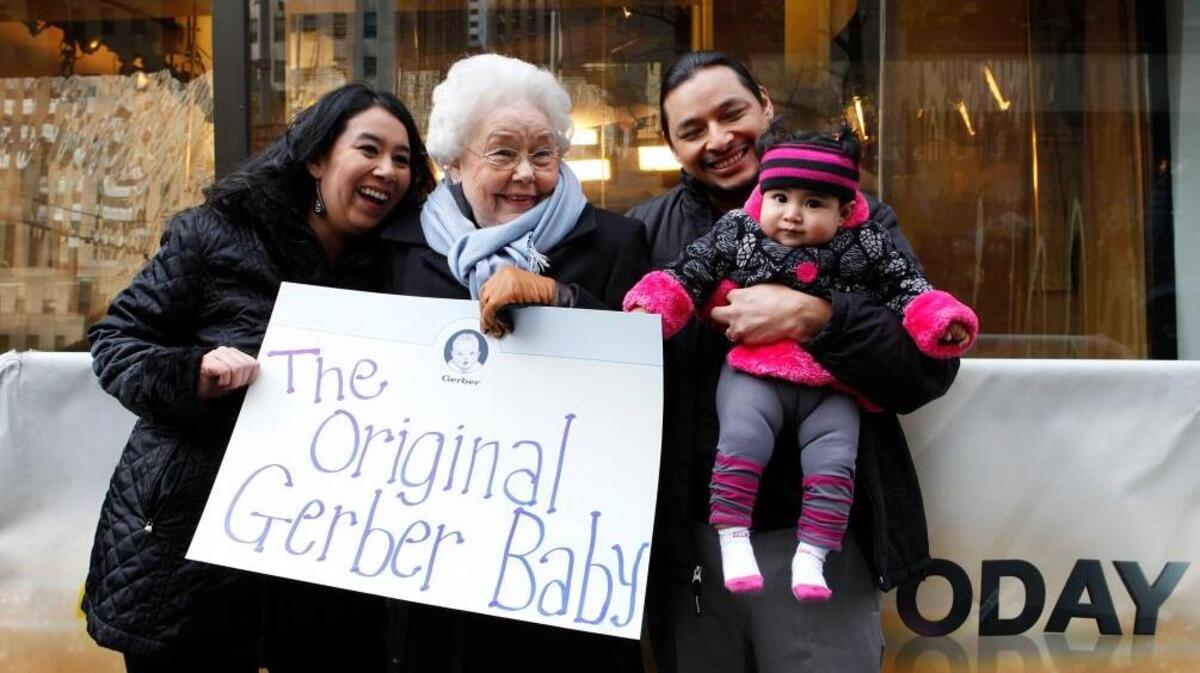 Ann Turner Cook, center, is the original face for the Gerber baby food company. She’s seen in 2012 outside studios for NBC’s “Today” with people who won a contest.