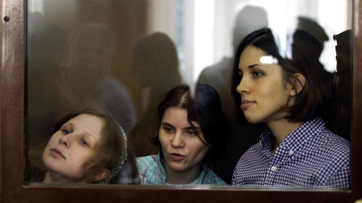 Members of the Russian feminist punk band Pussy Riot – from left, Maria Alekhina, Yekaterina Samutsevich and Nadezhda Tolokonnikova – stand behind a glass wall at a court in Moscow on July 30, 2012.