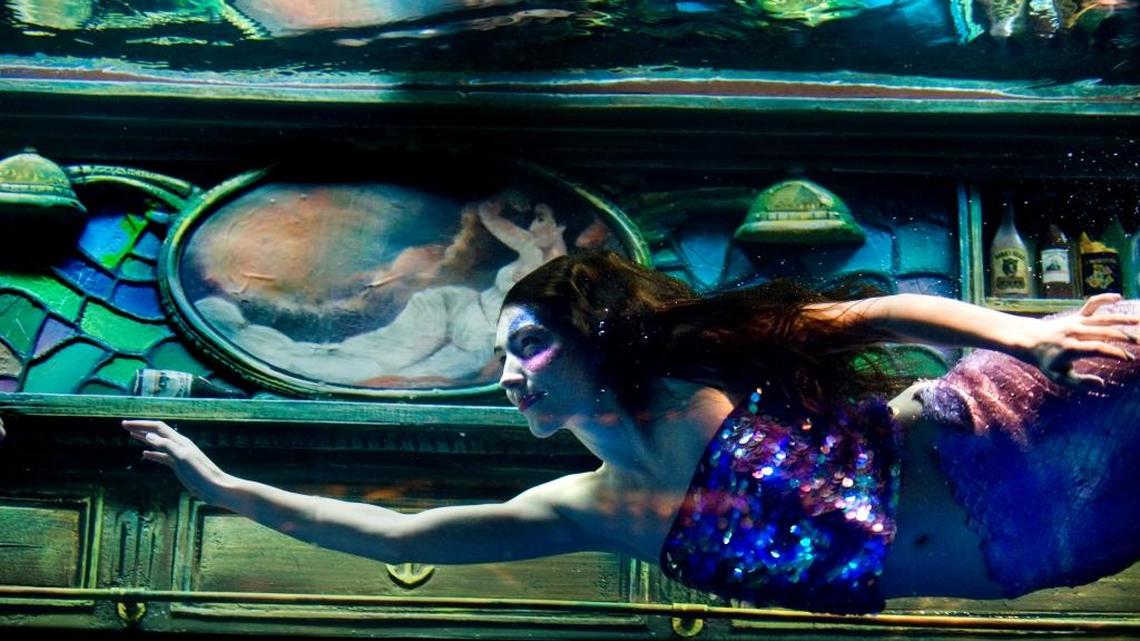 FILE -- Ellen Hancock practices her moves while swimming as a mermaid in an aquarium above the bar at Dive Bar on K Street, Thursday, Jan. 6, 2011. The bar is looking to hire more “mermen” for its weekend couple shows, according to a Facebook post.