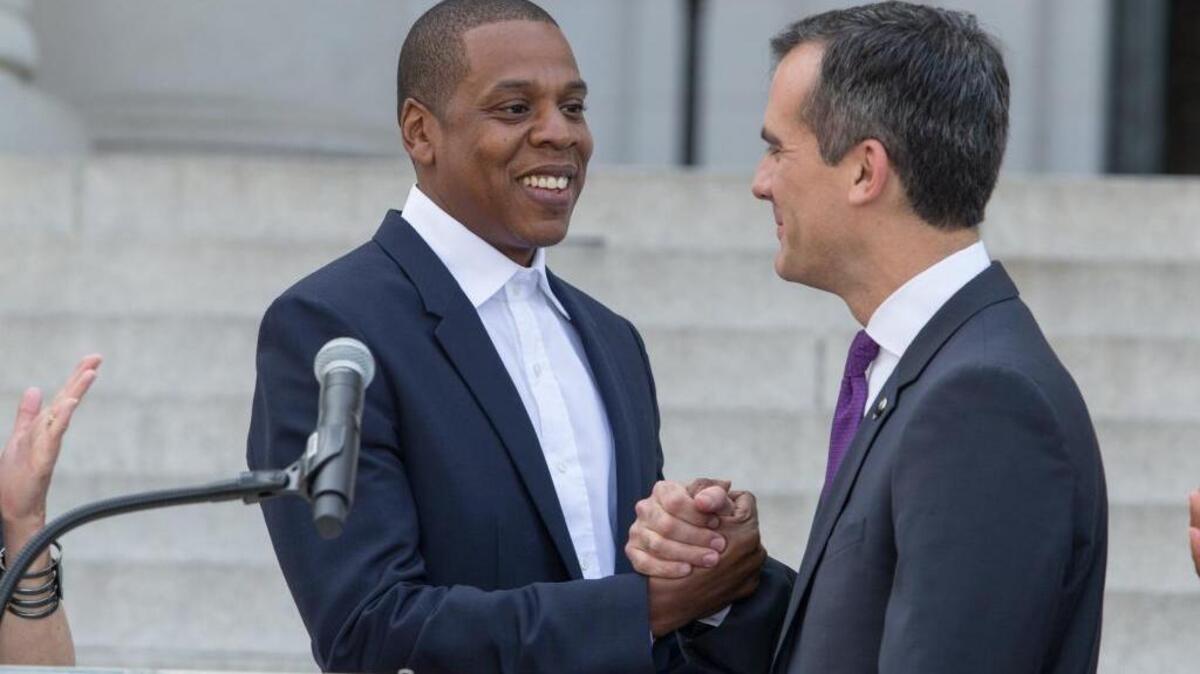 Jay-Z, also known as Shawn Carter, left and Mayor Eric Garcetti clasp hands as they announce the Made in America Festival from the steps of City Hall on April 16, 2014 in Los Angeles.