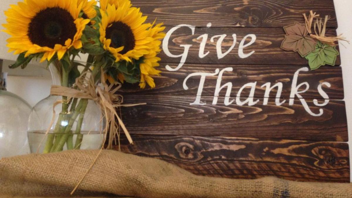 The writer’s completed pallet sign, accented with sunflowers and burlap. The writer plans to add pumpkins to the display as the holiday season approaches.