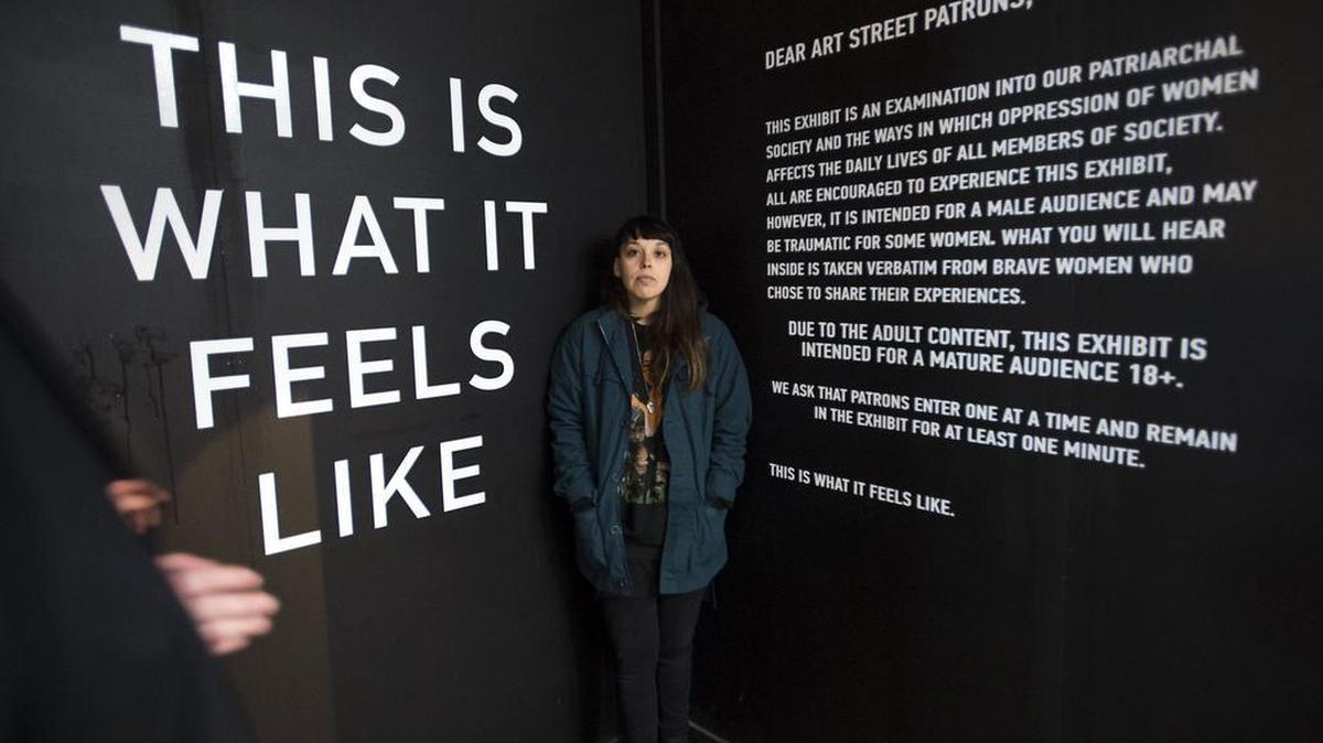 Terra Lopez stands with her “This is What it Feels Like” installation at ArtStreet. It’s primarily an audio exhibit for which participants wear headphones and hear examples of men’s catcalls toward women.
