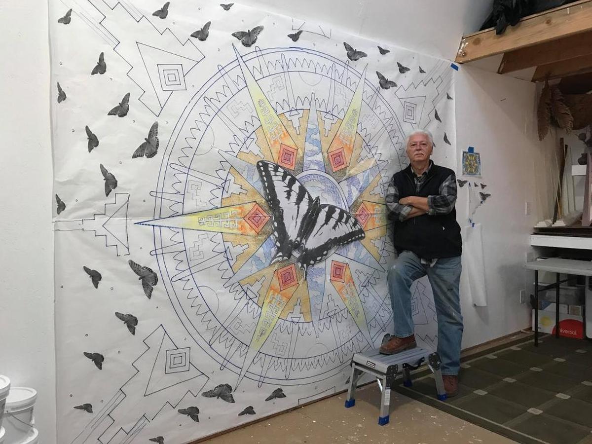 Artist Stan Padilla stands next to a mock-up of his mural “Flight” before it was installed at Golden 1 Center in 2018. 