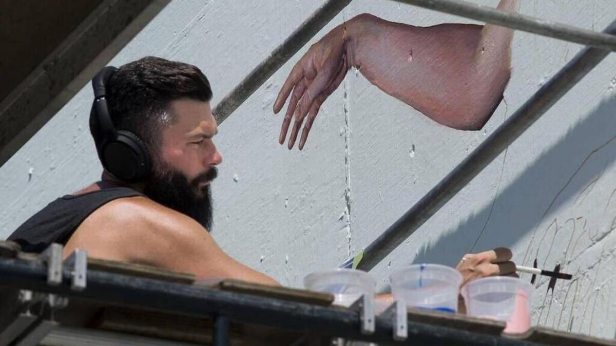 Mural artist Nate Frizzell works on a mural at 2000 K Street in Sacramento on Aug. 20, 2016, for the Sacramento Mural Festival.