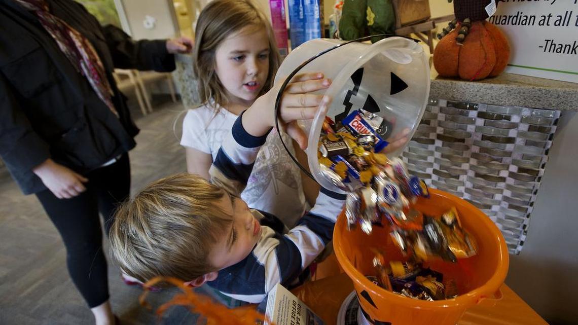Cliffy Storey 4, left, and his sister Audrey Storey 7 of Greenhaven pour candy into a bowl to be weighed at the Kids Care Dental offices in the Greenhaven area in 2013. California lawmakers sent Gov. Gavin Newsom a bill that would ban chemicals in certain candies and foods.