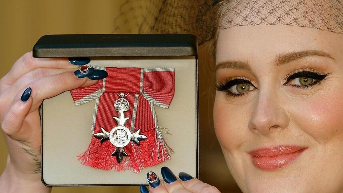 
British singer Adele Adkins holds her MBE for services to music presented to her by the Prince of Wales at Buckingham Palace in London, Thursday, Dec. 19, 2013. 
