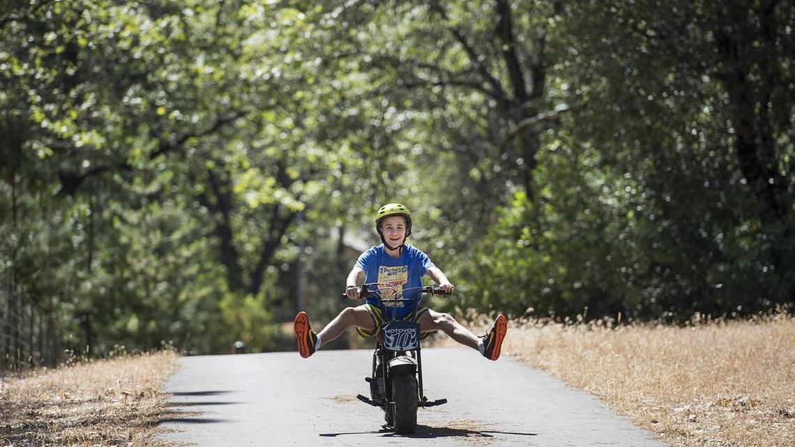 Matthew McGloughlin, 12, rides his motor scooter near his home on Sunday, July 10, 2016, in Sacramento, Calif.