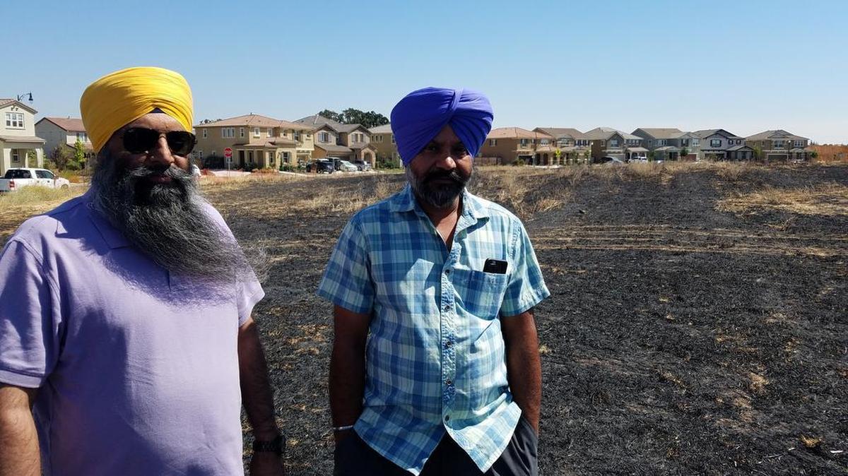 Sitak Singh Nijjar, a friend of slain Sikh grandfather Gurmej Singh Atwal, and Atwal's son Kamaljit Singh Atwal, at site where Elk Grove will be built to honor Sikh Americans.