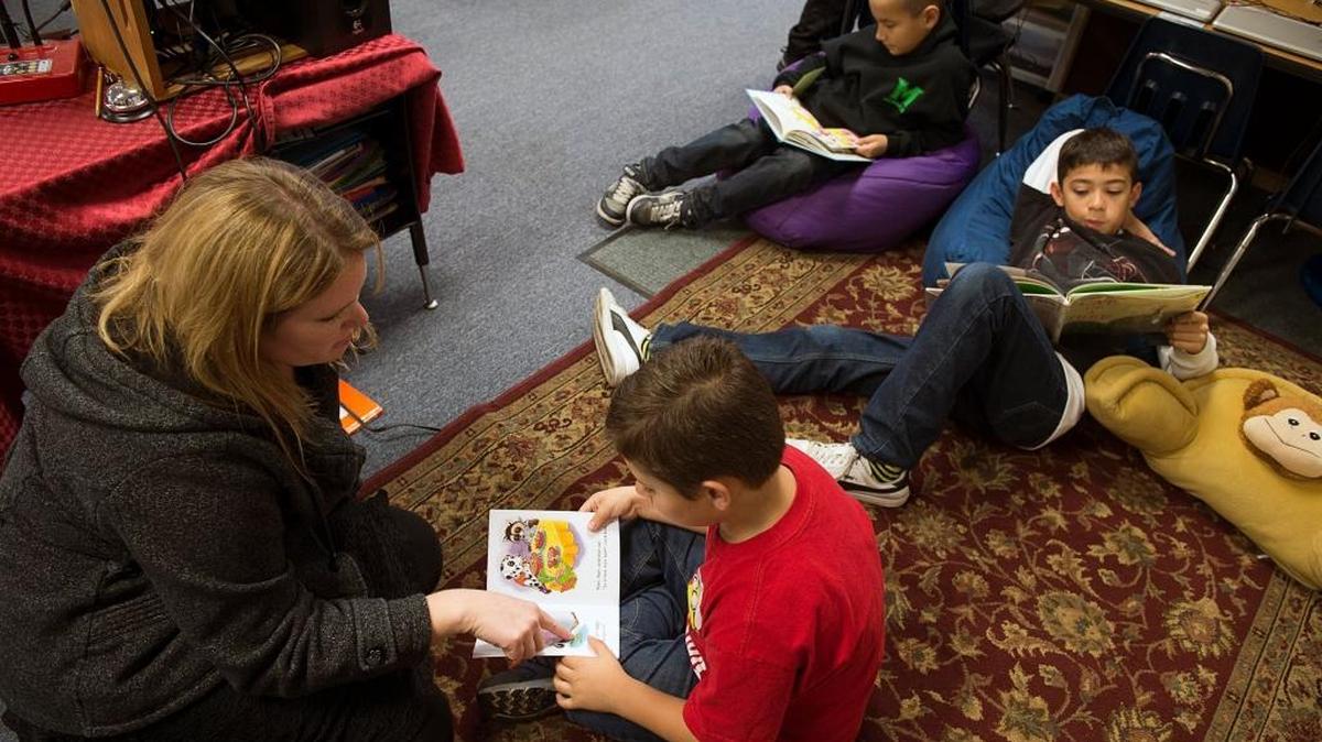Teacher Melody Swars reads with Michael Anders, 6, as Abraham Rivera, 9, back left, and Paul Johnson, 10, also read in their classroom at River Oaks Elementary in Galt in 2016. The Galt district ranked among the best in the area when it comes to third-grade reading performance.