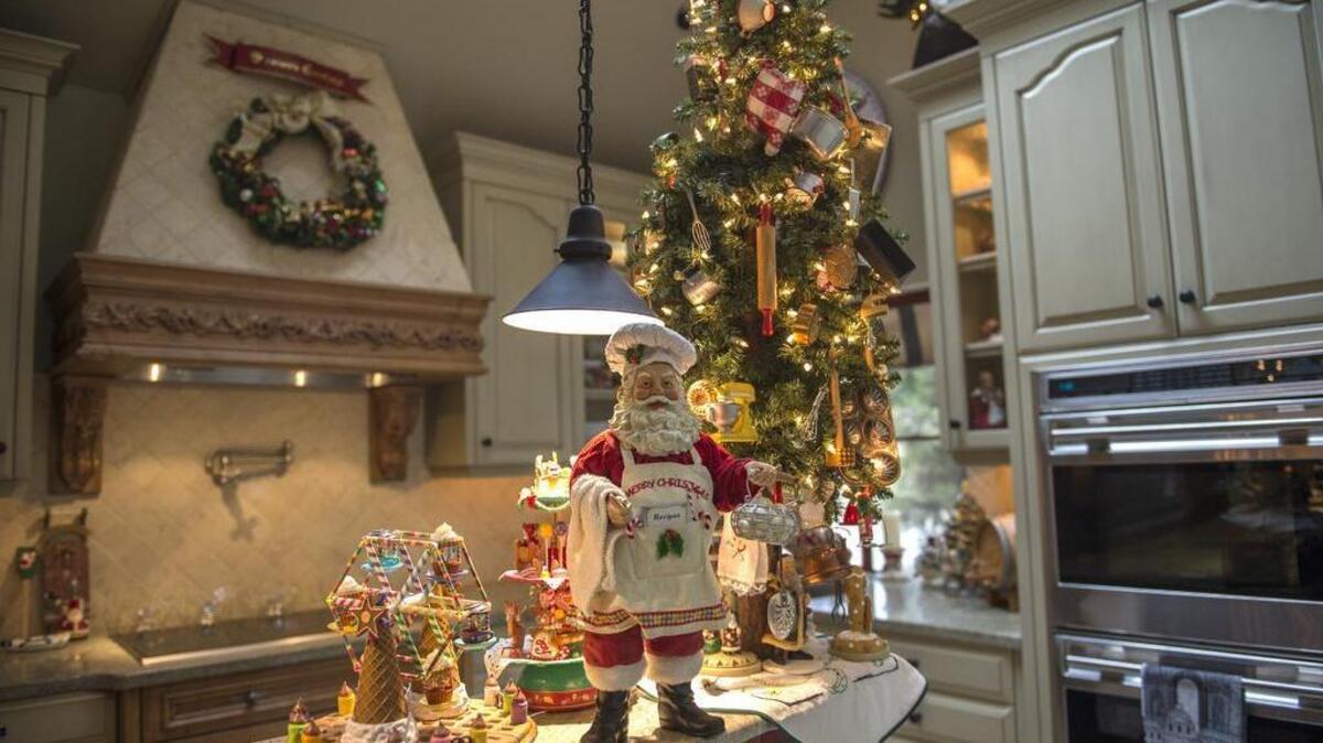 The Christmas tree in the Mike and Bobbie Voris’ kitchen is crowded with holiday ornaments. The rest of the three-story house is similarly themed.