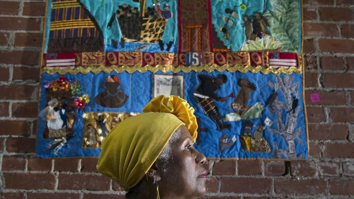 First-time quilter Trish Wade of Sacramento is photographed with her piece quilt at the Brickhouse Gallery and Art Complex in Oak Park on Aug. 4. The Oak Park gallery is presenting an unusual quilt show, “Never, Ever Forget,“ showcasing African-American quilts and nationally known experts. These cloth works of art often contain a powerful message that transcends generations.
