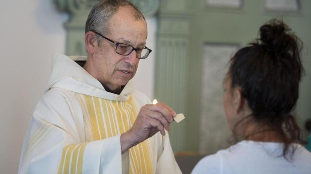 The pastor of St. Francis of Assisi, the Rev. Ken Laverone, offers communion to a parishioner during a noon mass in the church chapel on Tuesday, May 24, 2016 in Sacramento, Calif. A transition is underway in which Franciscan priests will no longer be pastors at what has long been one of the most diverse and well-attended Roman Catholic churches in the Sacramento diocese. The order simply does not have enough priests to go around.