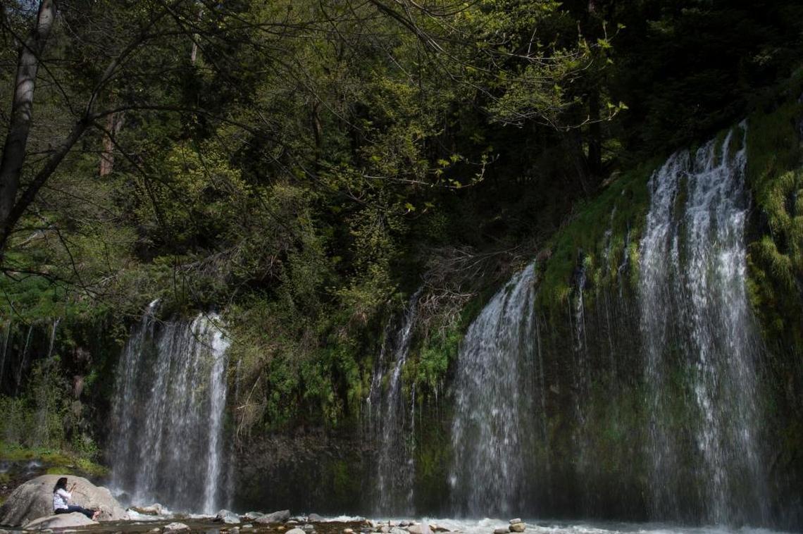 A woman sits on the banks of the Sacramento River near the town of Dunsmuir to enjoy the breathtaking view of Mossbrae Falls. The waterfalls are about 50 feet high and 250 wide during the spring snow melt from Mount Shasta. Mount Shasta’s giant peak, the largest in north America, is a mountain of mystery, attracting spiritual questers from across the globe. We explore the myth, mystery and magic of the mountain.