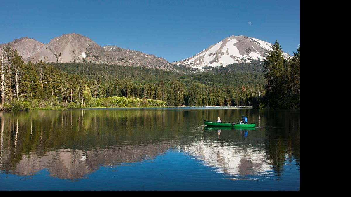 
Chaos Crags, top left, and Lassen Peak (with snow) loom beyond occupants of a canoe on Manzanita Lake in Lassen Volcanic National Park in 2006.
