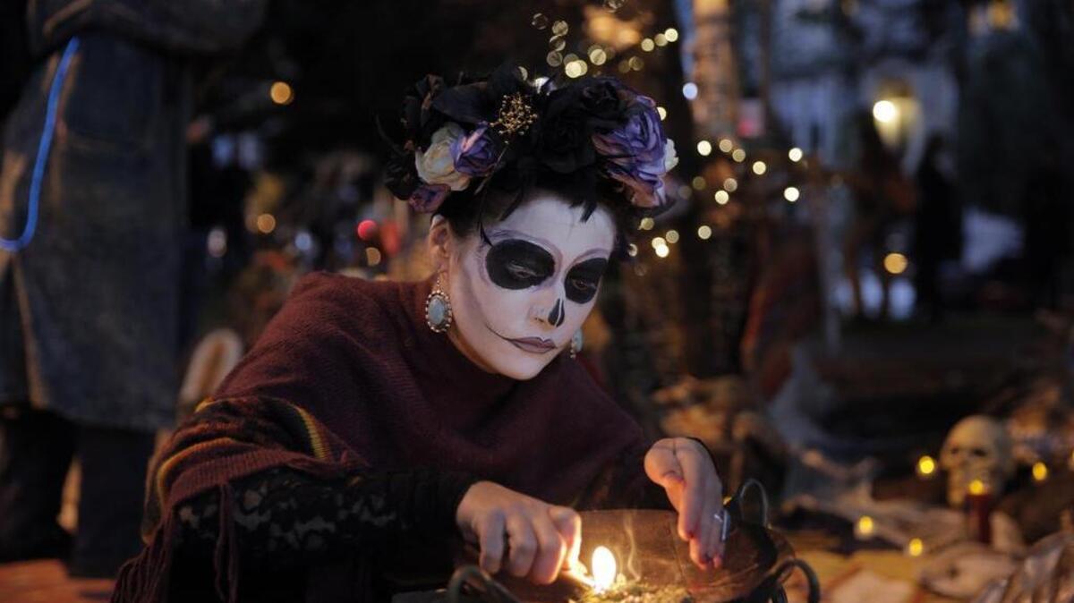Sarah Wells lights incense during a Day of the Dead celebration a year ago in the Mission District in San Francisco.