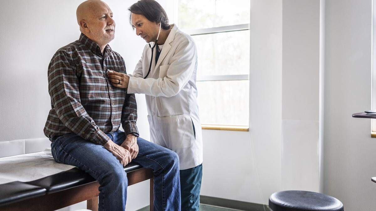 Doctor listening to senior mans heart with stethoscope