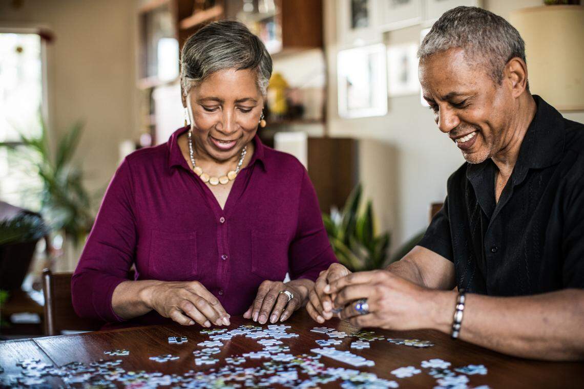 Senior couple assembling puzzle at home