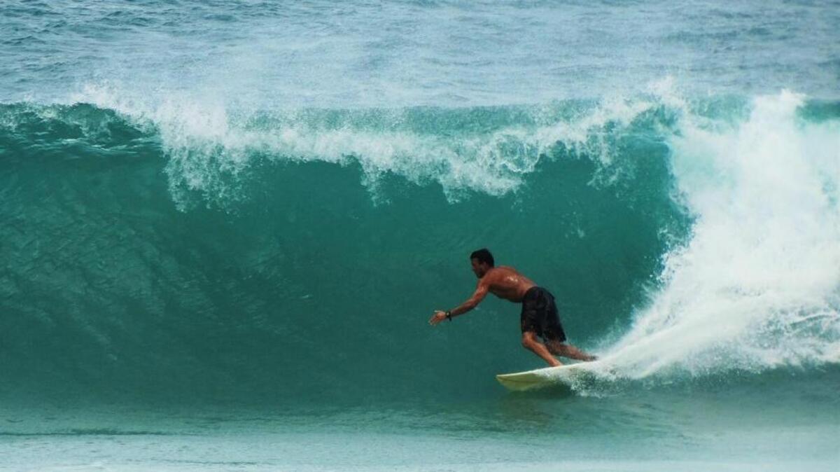 A board surfer gets “roofed” by his wave on a beach in Kaua’i.