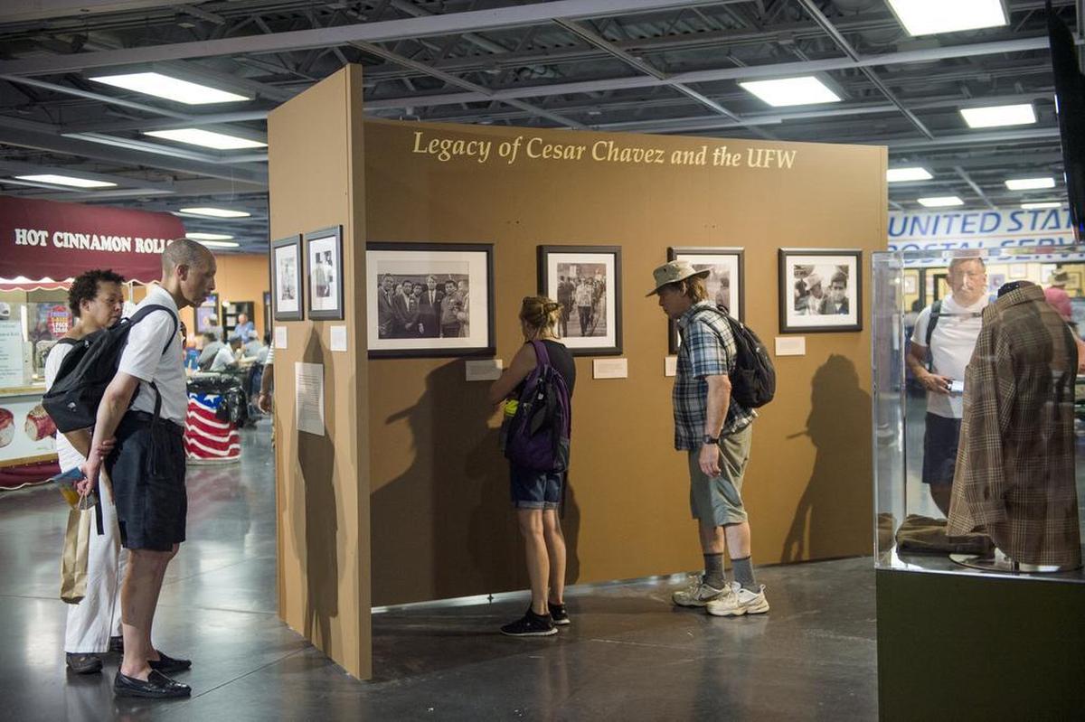 Fairgoers stop to look at the United Farm Workers exhibit at the California State Fair on Friday, July 14, 2017, in Sacramento, Calif.