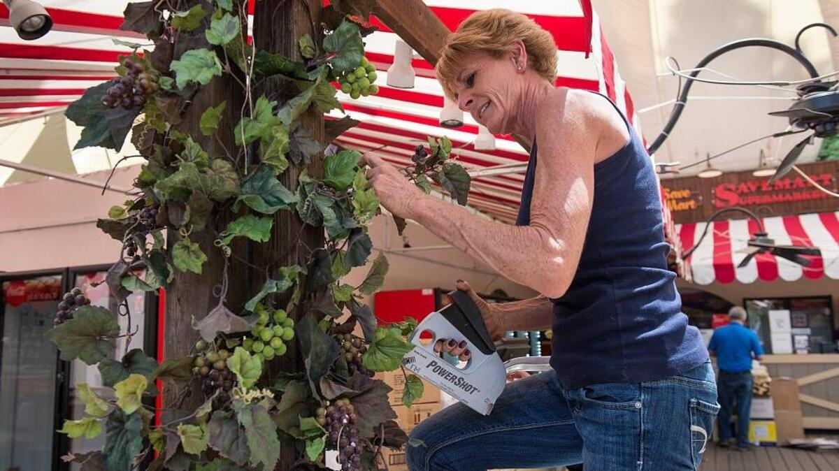 Kristie Wages decorates a stall in the wine garden in preparation for the California State Fair on Tuesday, July 5, 2016. The fair will open on Friday, July 8, 2016.