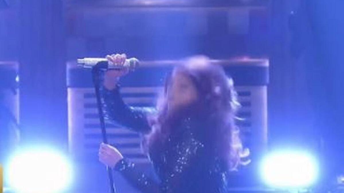 Singer Meghan Trainor grabs the microphone as she falls during a performance on ‘The Tonight Show.’