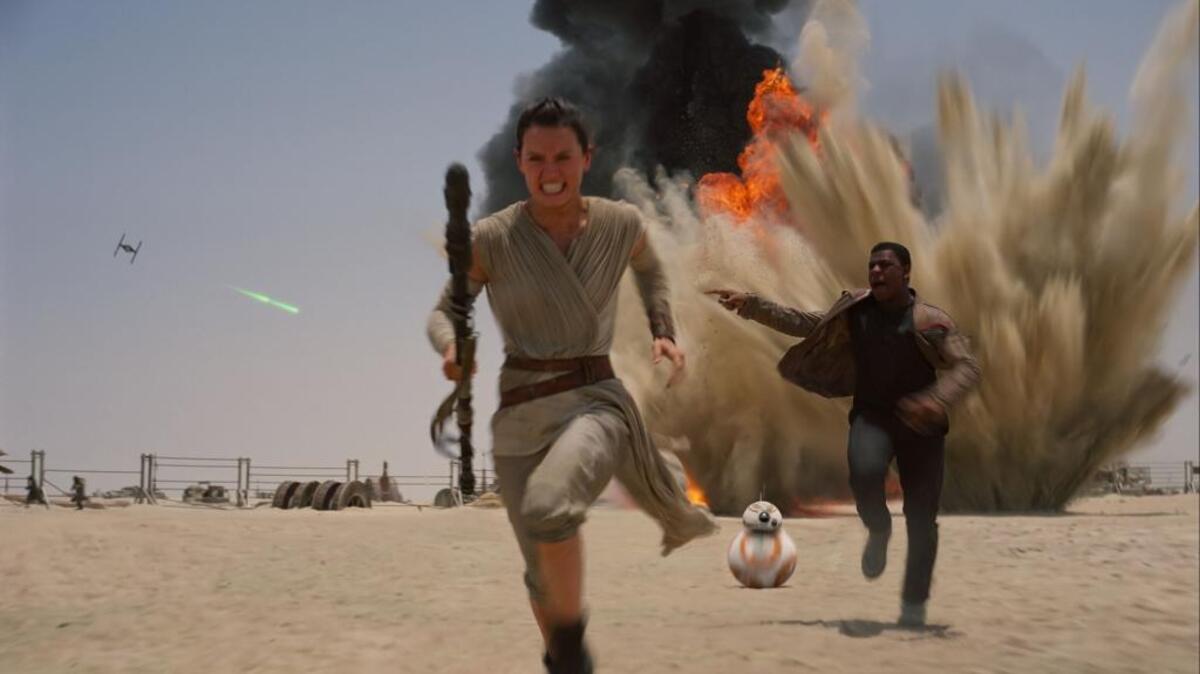 This photo provided by Disney shows Daisey Ridley as Rey, left, and John Boyega as Finn, in a scene from the new film, “Star Wars: The Force Awakens.”