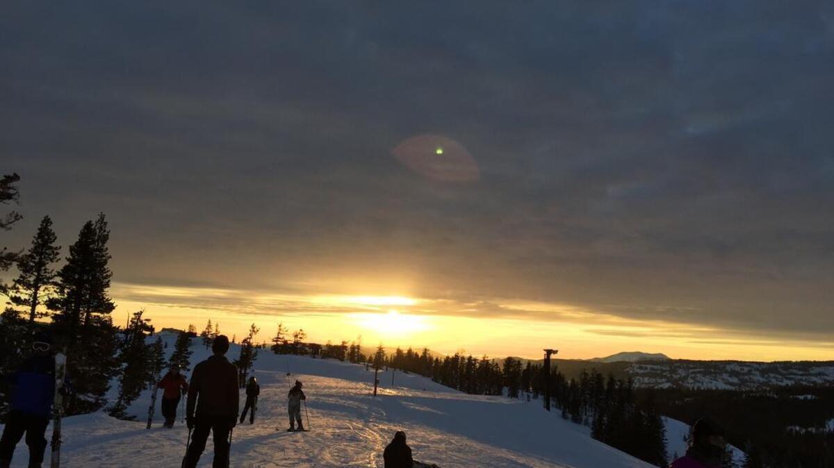Skiiers and snowboarders watch the sunset at Boreal.