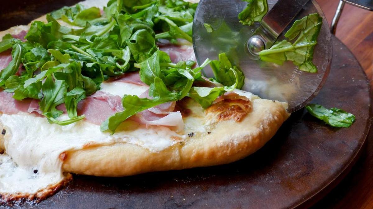 This prosciutto and arugula pizza is sure to impress your pals without busting up your budget. (See recipe, Page 2D.)