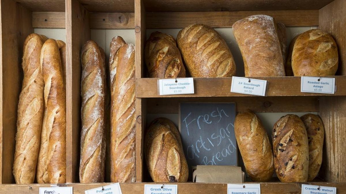 FILE - A selection of artisan breads on display behind the register at the Grateful Bread on Wednesday, Aug. 12, 2015 in Sacramento, Calif. Recently opened San Francisco bakery Les Gourmands received attention for charging $29 for its artisan brioche.