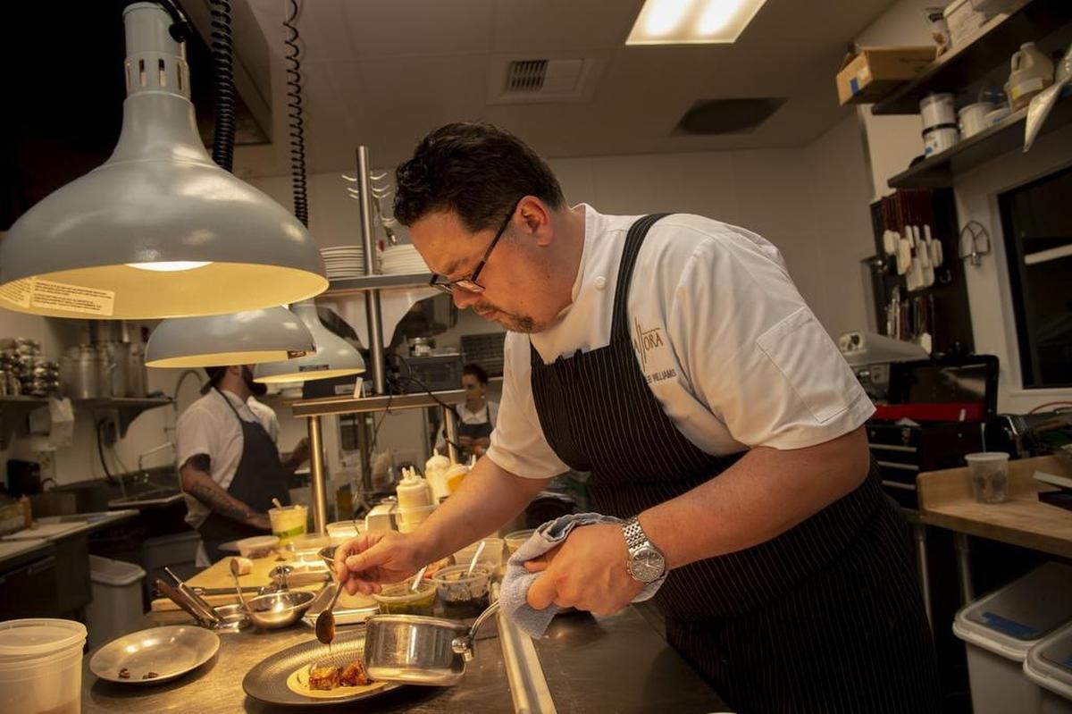 Allora chef Deneb Williams prepares a dish in a building that previously was home to a floral business.