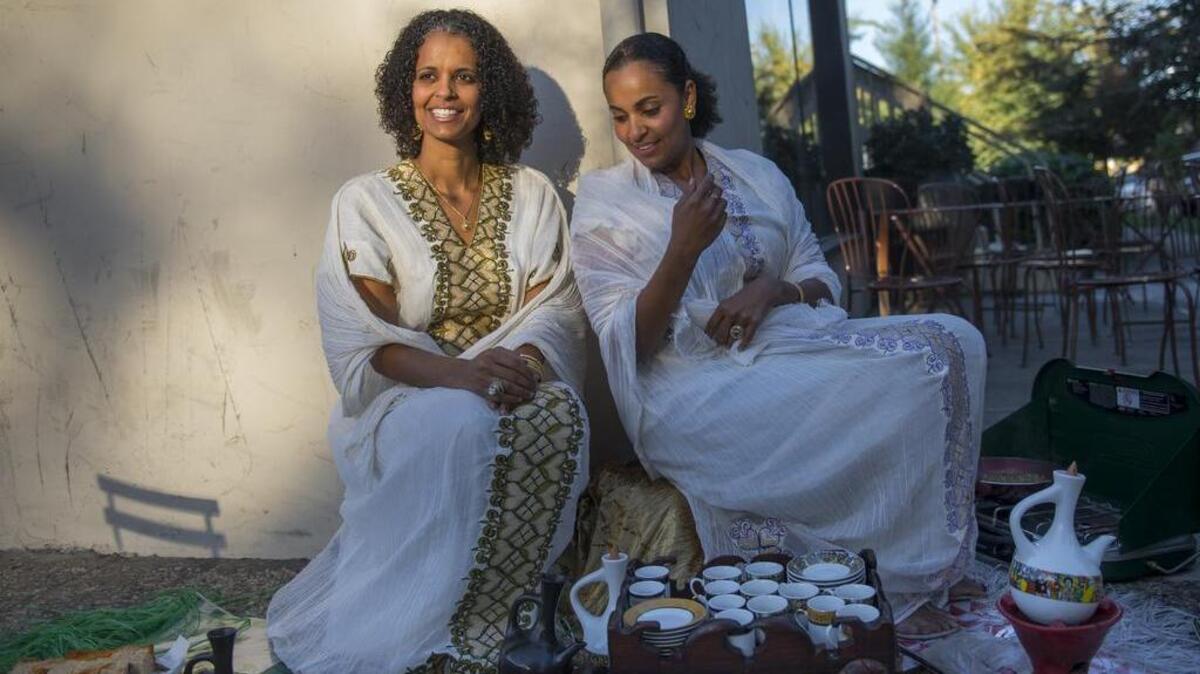Makeda Berhane, left, and her sister, Sabrina Berhane, owners of Teferet Coffee in East Sacramento, perform a traditional Ethiopian coffee ceremony outside their shop off H Street earlier this month.