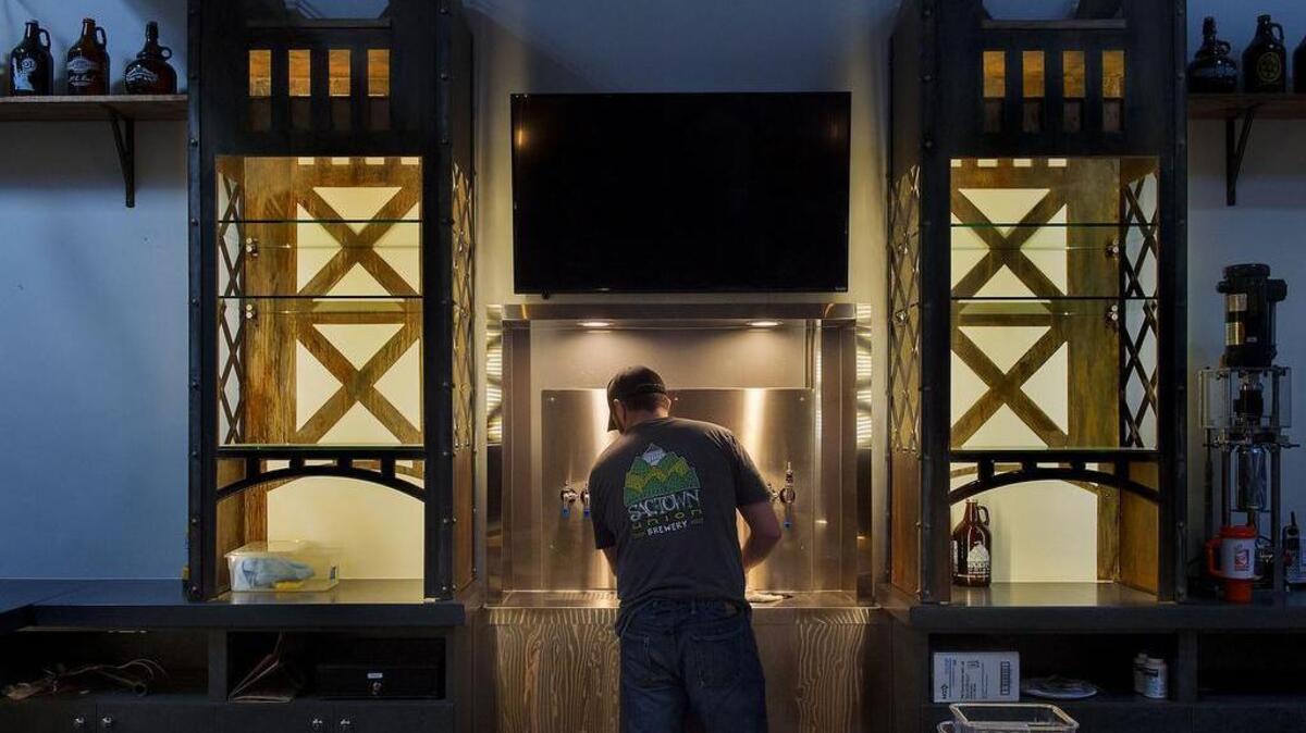 Quinn Gardner prepares the taps at the Sactown Union Brewery in Sacramento on Tuesday, February 16, 2016. Sactown Union is one of 4 or 5 new breweries racing to open in time for Beer Week at the end of February. The design of the bar suggests Sacramento's Tower bridge.