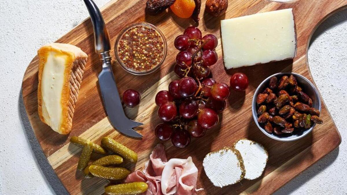 Clockwise, from top left: Chimay cheese, mustard, dried figs and apricots, grapes, Manchego, honey-roasted pistachios, goat cheese, prosciutto and cornichons.