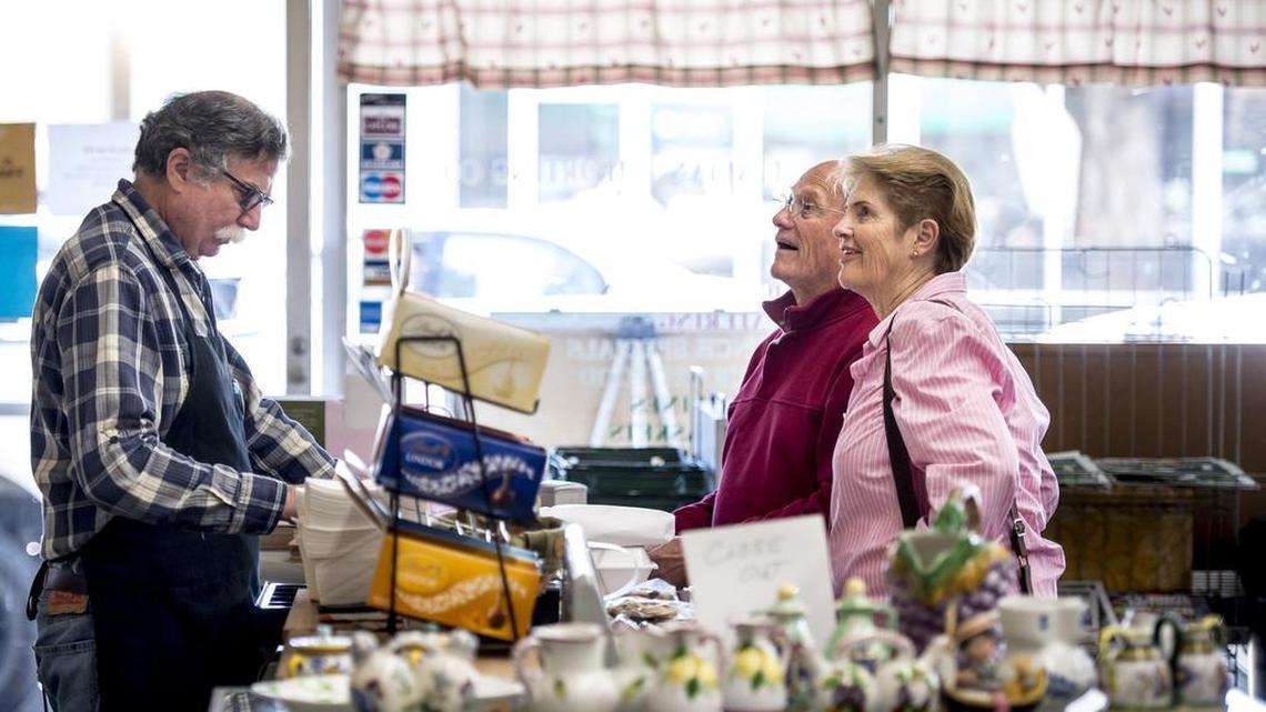 Larry Otten, whose Italian Importing Co. is closing in April, rings up the lunch purchase of Mike and Valerie Lake on Feb. 28. He’s been behind the counter there for 27 years.