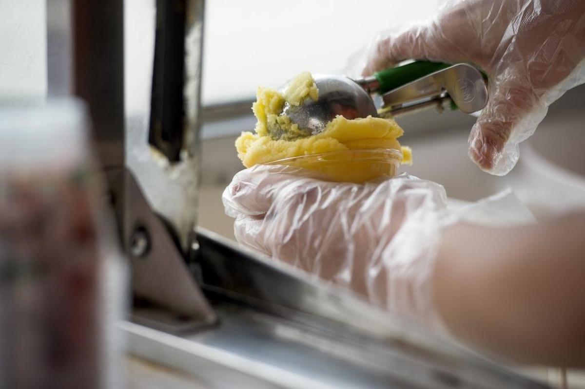 Grace Cook presses down on a scoop of Merlino's orange freeze during a Sacramento River Cats game at Raley Field.