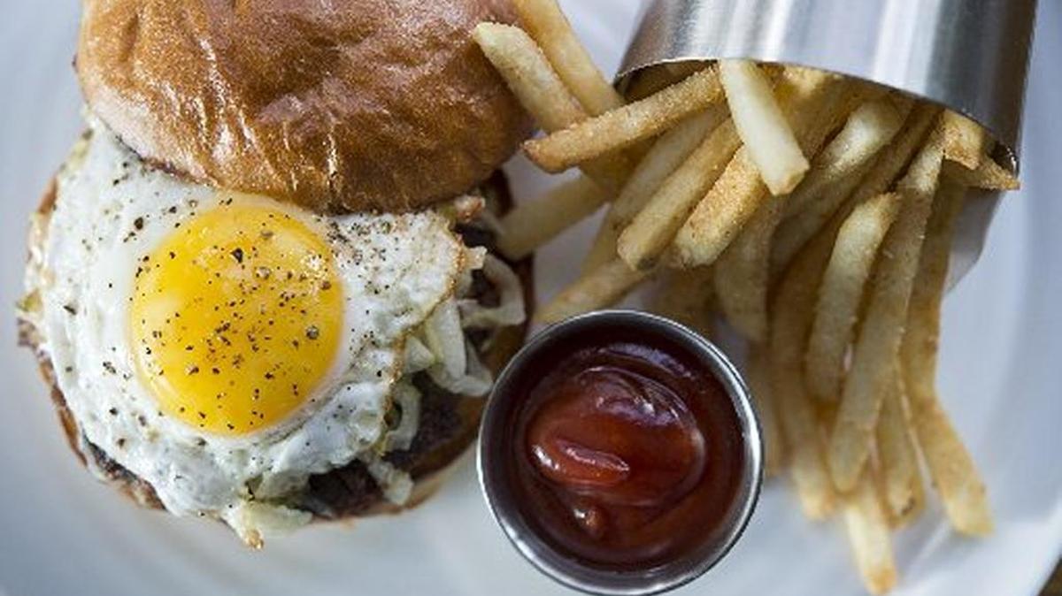 Saddle rock burger with egg, beef, brie, bacon and shallot seared into the patty on a roll with house pickles, lettuce, fancy sauce and fries at Saddle Rock on Monday October 17, 2016 in Sacramento, Calif.