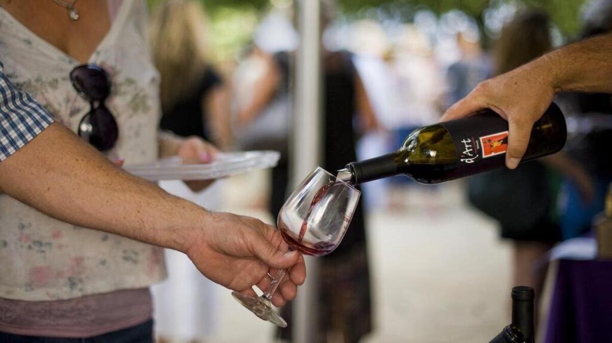 Dave Dart distributes samples of his D’Art wine during the Grape Escape at Cesar Chavez Park, June 2, 2012.