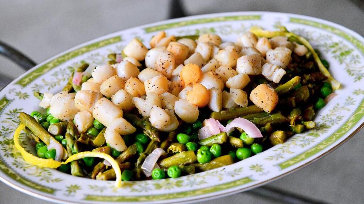Flash cook scallops on both sides and serve them with shallots, peas, asparagus and a white wine-lemony sauce.