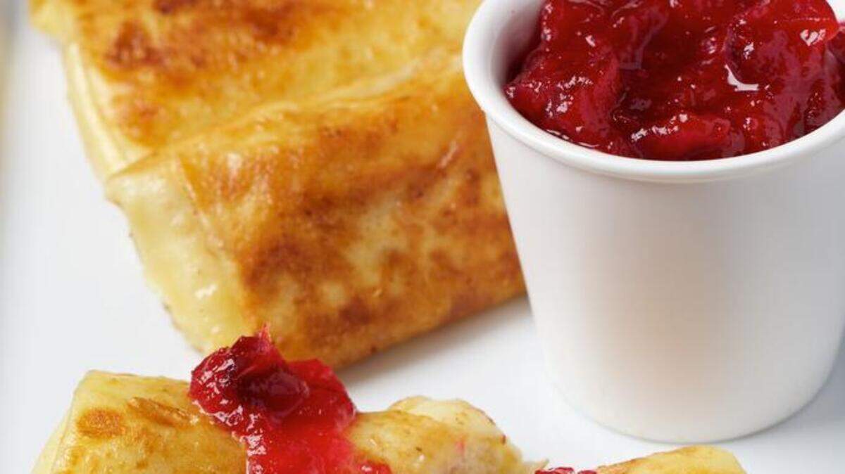 Cheese blintzes are accompanied by chunky berry sauce made with cranberries.