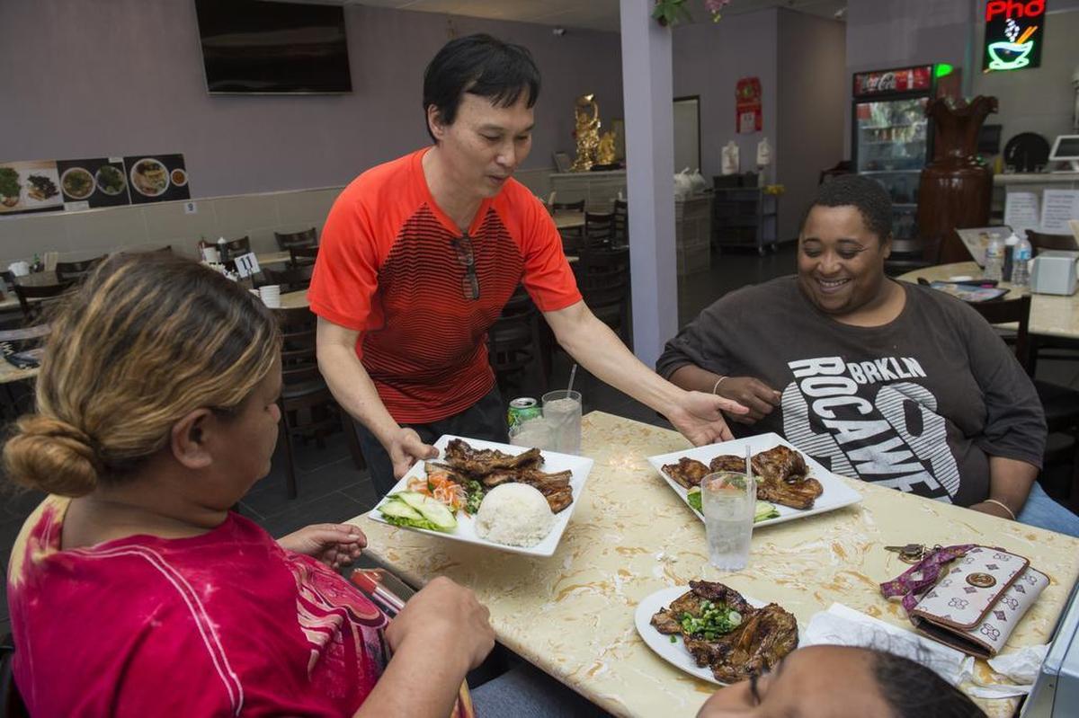 Co-owner Hung Tran serves a late lunch to Joseph McGee and Darlene Falealili at Com Tam Dat Thanh in south Sacramento in 2018.