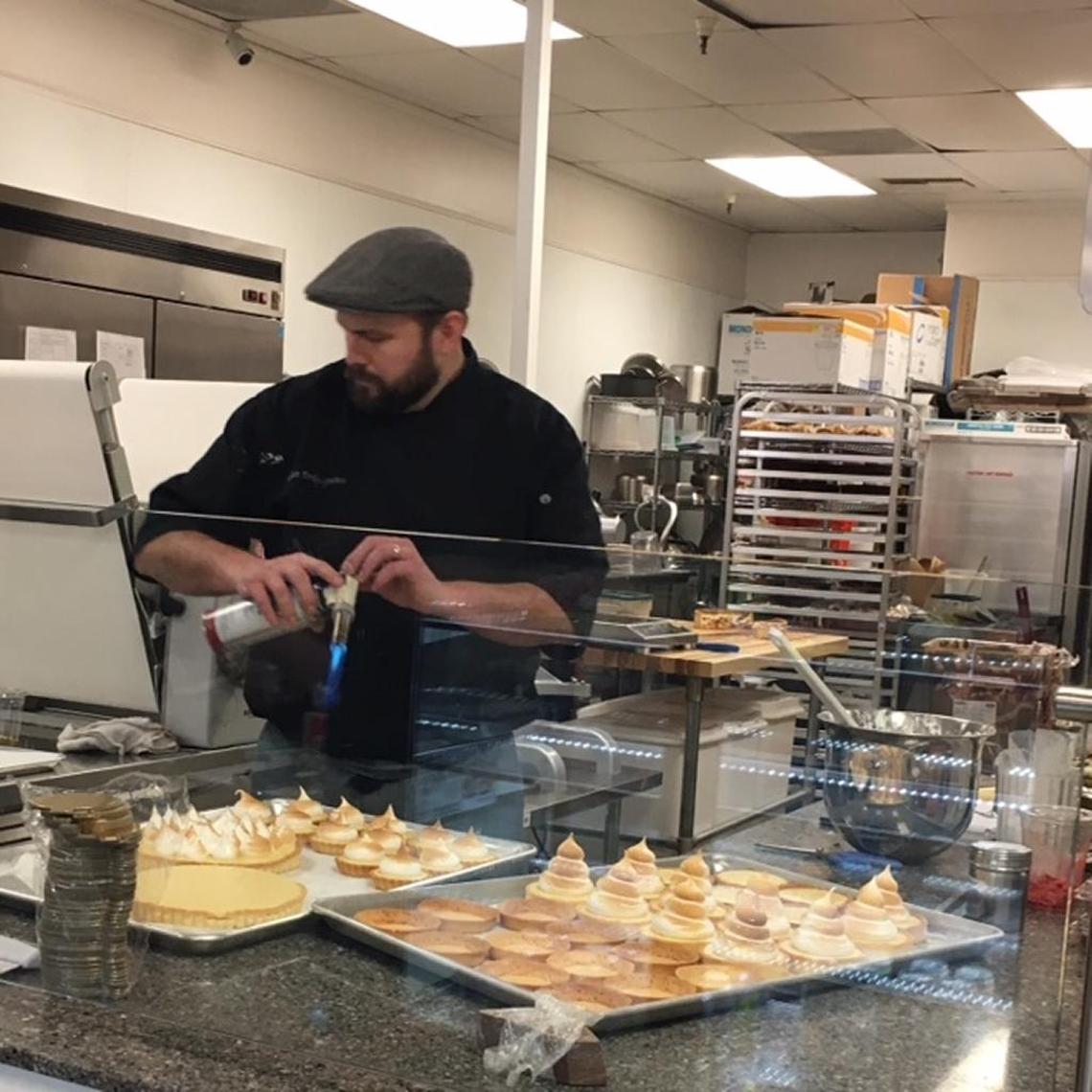 Julian Perrigo-Jimenez torches meringue topping in the open kitchen of Julian’s Patisserie & Cafe, which he co-owns with wife Ashley Perrigo-Jimenez.