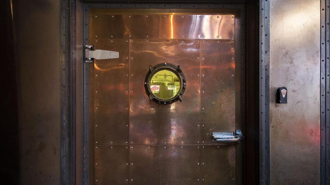 
A copper-clad door with porthole leads to the brewery at Oak Park Brewing Co. 
