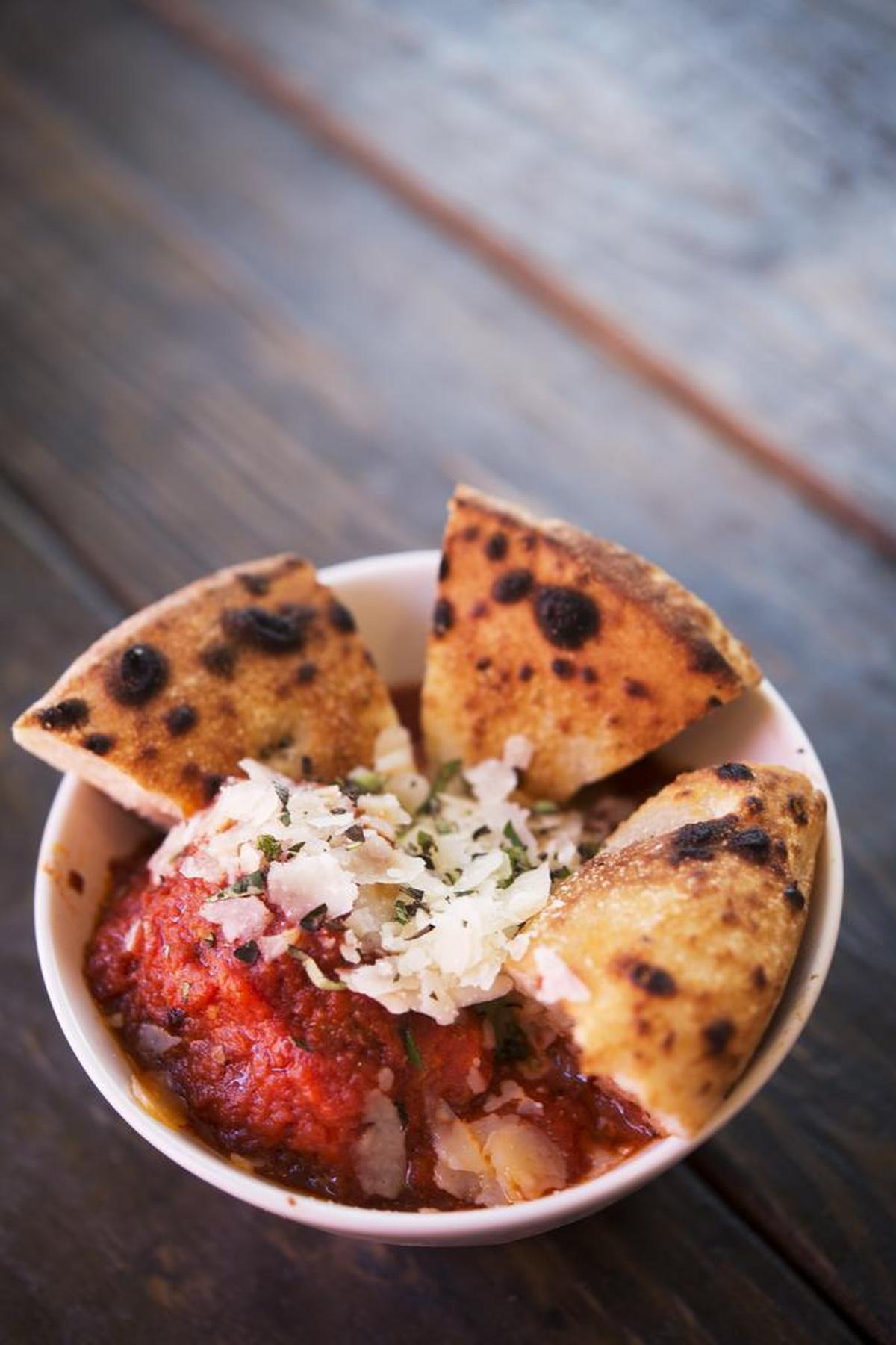 Cannonballs, meatballs with ground pork, ground beef and smoked meats covered in Italian grave topped with Shaved grand padding &fresh oregano, served at the Federalist Public House Wednesday June 3, 2015 in Sacramento. The Federalist Public House is a beer spot and pizza restaurant built from recycled shipping containers.