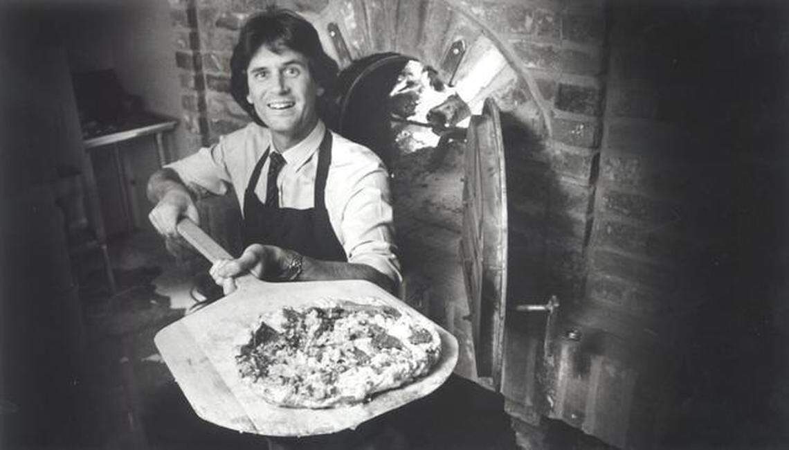 Randy Paragary removes a pizza from a new $7,000 brick oven at his 28th Street restaurant 1983.