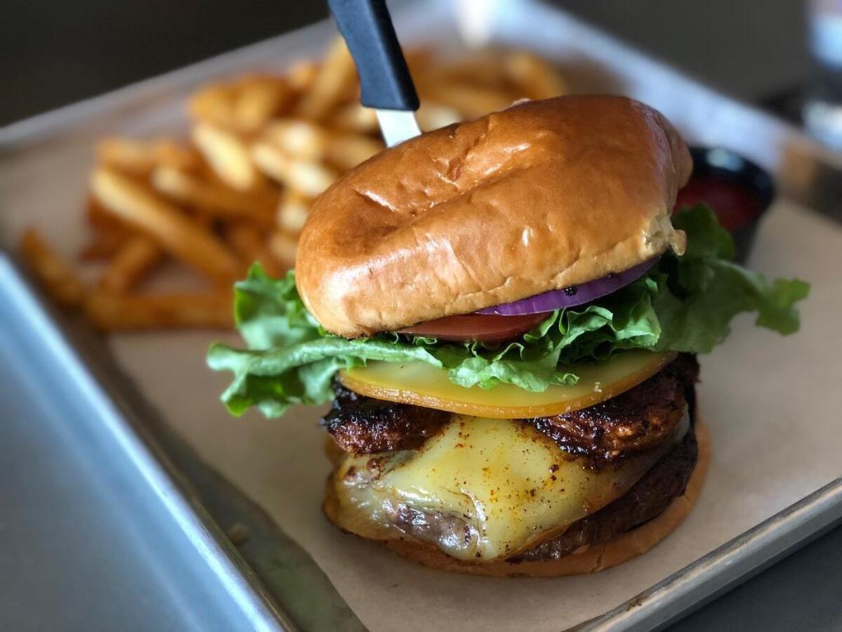 Shrimp-chorizo burger with french fries at Serpentine Fox Prohibition Grille.
