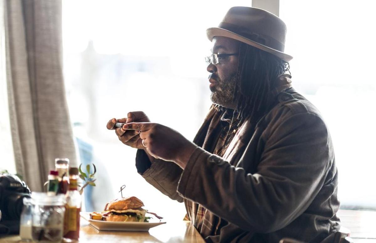 Rodney Blackwell takes a food photo at Bacon & Butter. “In this day and age, social media is almost as important as having a phone line,” the social media expert said.