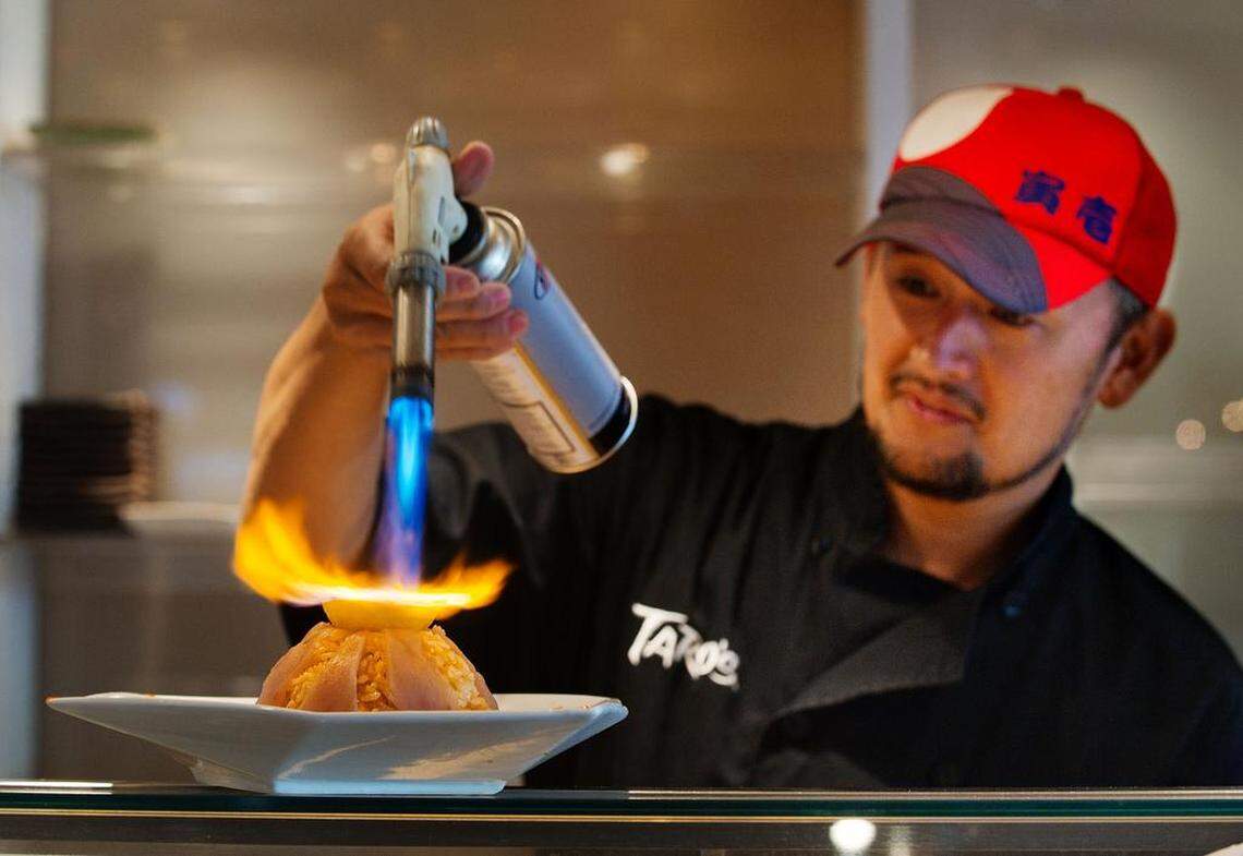 Sushi chef Taro Arai makes a sushi creation with rice, green onion, jalapeno peppers, lemon, tuna and rum that he called “Volcano Rice” at Mikuni restaurant in Sacramento in 2011.