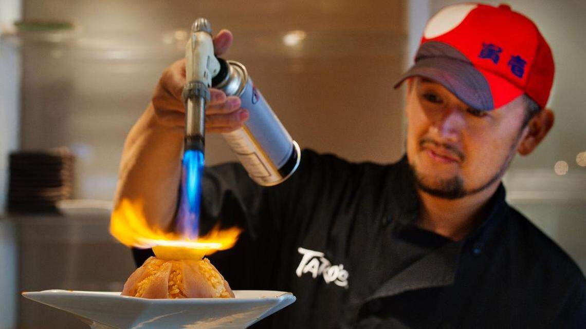 Sushi chef Taro Arai makes a sushi creation with rice, green onion, jalapeno peppers, lemon, tuna and rum that he called “Volcano Rice” at Mikuni restaurant in Sacramento in 2011. Vanshow California, a subsidiary of a Tokyo conglomerate, on Thursday announced the acquisition of the Mikuni Restaurant Group.