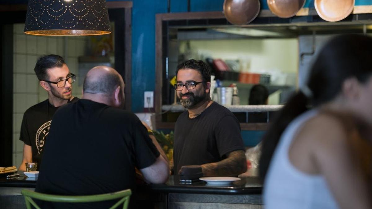 Chef Aimal Formoli, center, talks with a customer in 2016 at Formoli’s Bistro in East Sacramento.